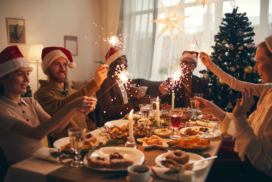 Ein Gruppe von Menschen feiert zuhause gemeinsam das Weihnachtsfest